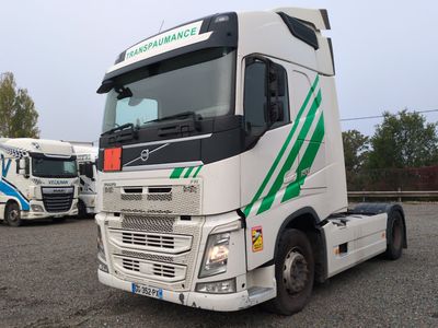 un camion blanc avec des bandes vertes garé sur un parking