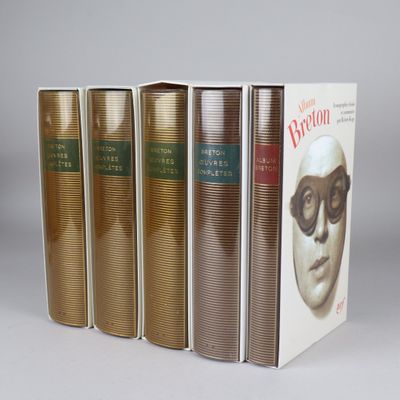 three books are lined up in a row on a gray surface