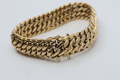 a gold bracelet on a white background