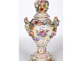 un gros plan d'un vase posé sur un socle et orné de fleurs