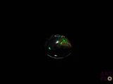 an image of a soap bubble floating in the dark