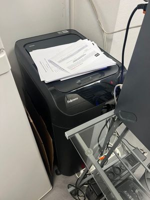 a stack of papers sitting on top of a desk next to a washing machine