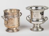 two silver vases sitting next to each other on a table