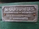 a close up of a metal plate on a green bench