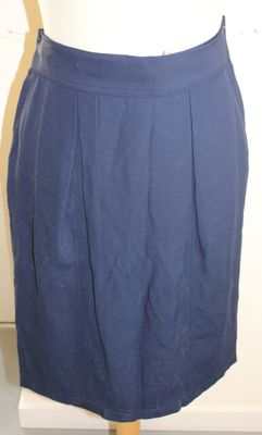 une jupe bleue posée sur un présentoir à mannequin, avec un haut blanc