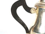 a silver coffee pot with a handle on a white background
