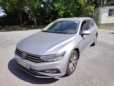 the volkswagen passat is parked in a parking lot with trees in the background