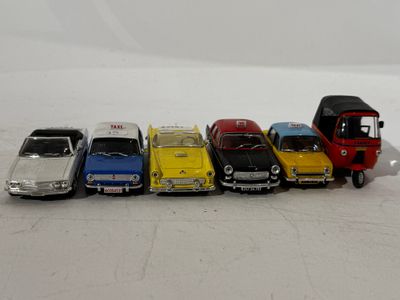 several toy cars are lined up next to each other on a white surface