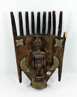 une image représentant un peigne en bois sur lequel est sculpté un visage