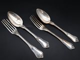 three silver spoons and a fork on a black surface