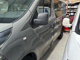 a silver van parked in a garage next to a white car