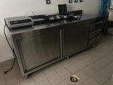une cuisine équipée d'armoires et d'appareils électroménagers en acier inoxydable
