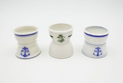 three white cups with blue designs on them sitting next to each other