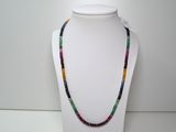 un gros plan d'un collier orné de perles multicolores porté par un mannequin