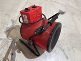 a red blower sitting on the floor next to a pair of pliers