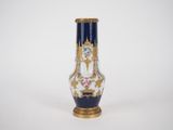 une image représentant un vase bleu et doré orné de fleurs