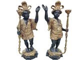 une paire de figurines noires et dorées représentant un homme et une femme