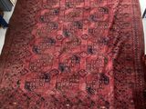 un grand tapis rouge posé au sol, à côté d'une chaise