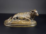 statue en bronze représentant un mouton couché sur une surface noire