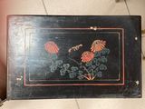 a black box with red flowers on it on the floor