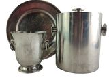 a silver ice bucket and a silver cup next to each other