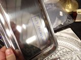 a person holding a silver tray with a name on it