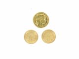 trois types différents de pièces d'or sur une surface blanche