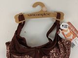 un soutien-gorge marron et blanc orné d'un nœud marron, suspendu à un cintre en bois