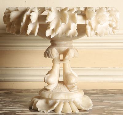 a white marble pedestal with a bird on top of it