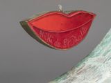 a christmas ornament with a red lip on it