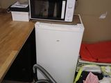 une petite cuisine équipée d'un micro-ondes et d'un lave-linge