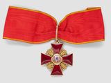 une image représentant un ruban rouge orné d'une croix dorée