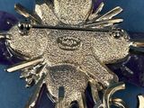 purple amethorate and silver broochle with a cross on it