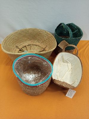 trois paniers tressés sont posés sur une nappe orange, sur une table