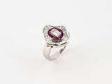gros plan d'une bague en diamant et rubis sur fond blanc