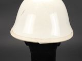 a white helmet on a black base against a gray background
