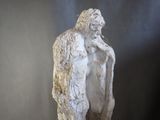 statue of a man with a broken arm on a wooden base