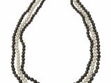 un collier à trois rangs composé de perles noires et blanches