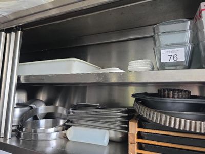 une étagère en métal sur laquelle sont posés des casseroles et des poêles
