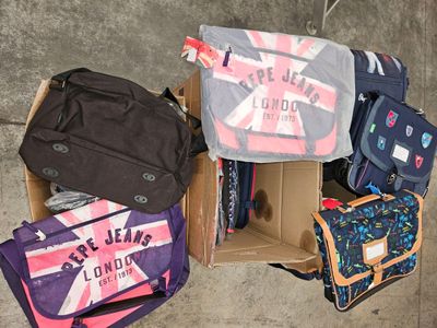 several pieces of luggage sitting in a cardboard box on the ground