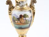 un vase en or orné d'une image représentant un château