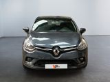 the front of a grey car in a room with a white wall