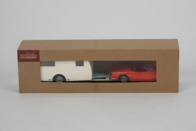 une voiture rouge et une remorque blanche dans une boîte en carton