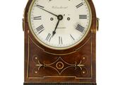 une horloge en bois avec des chiffres romains sur le cadran
