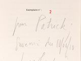 an open book with a handwritten page on it sitting on a table