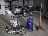 Les véhicules sont garés dans un garage où se trouvent de nombreux outils et équipements