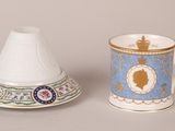 two cups and a saucer sitting next to each other