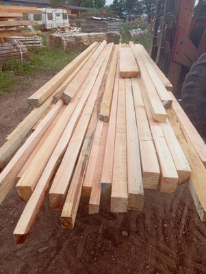 a pile of wood sitting on the ground in front of a tractor