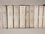 plusieurs vieux livres sont alignés sur une surface blanche