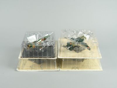 deux petits avions miniatures posés dans des boîtes en plastique sur une table